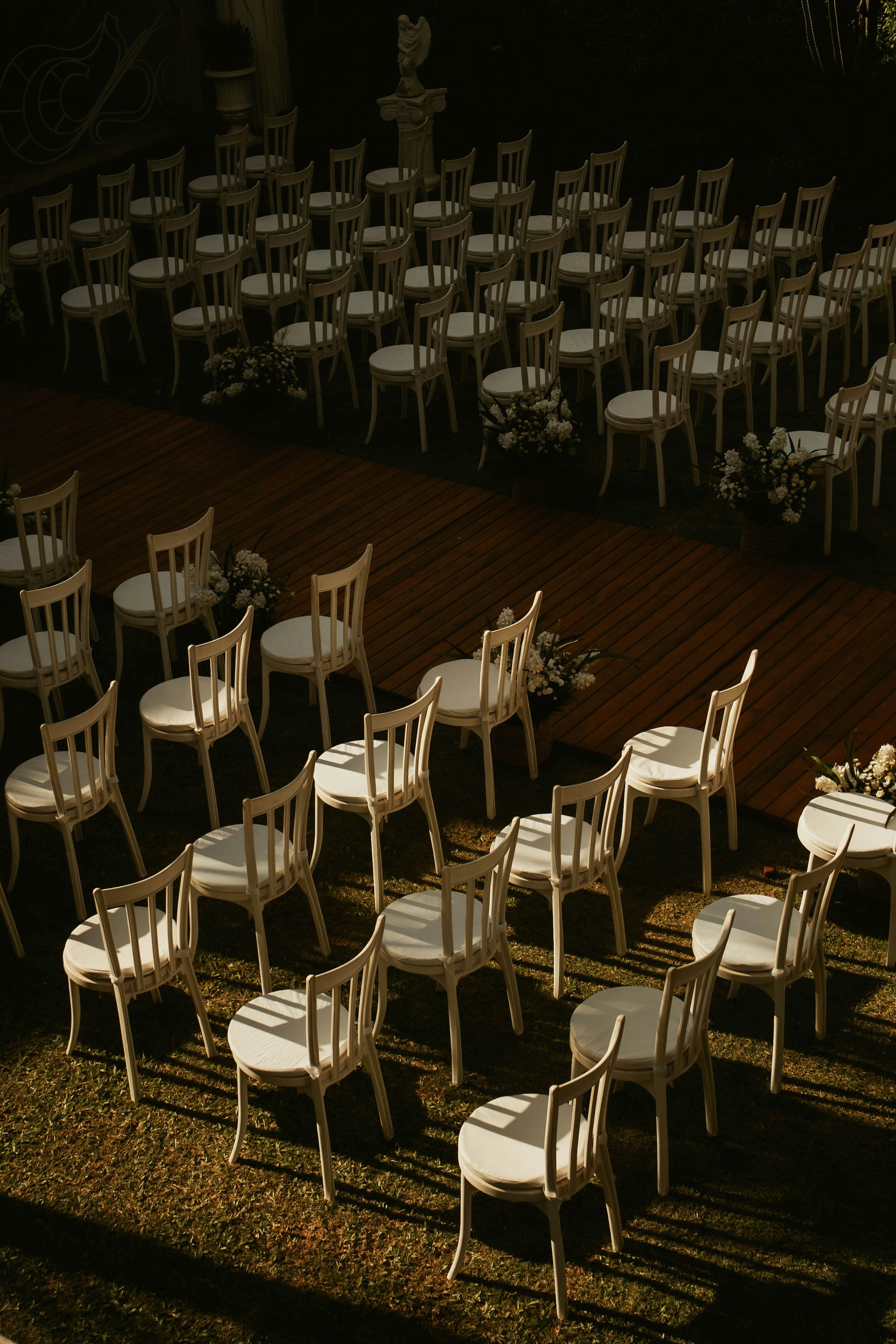 Rows of empty white chairs set up outdoors for an event